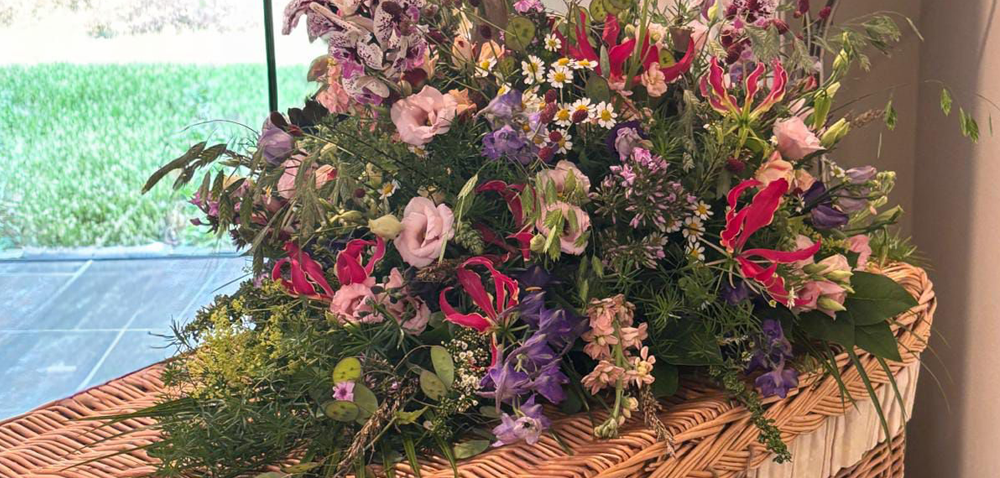 Bloemen op de uitvaartmand geven de uitvaart een persoonlijke betekenis